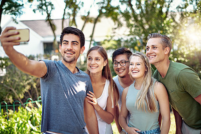 Buy stock photo Cropped shot of a young group of friends taking selfies while enjoying a few drinks outside in the summer sun