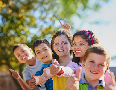 Buy stock photo Shot of a diverse group of children showing thumbs up outside