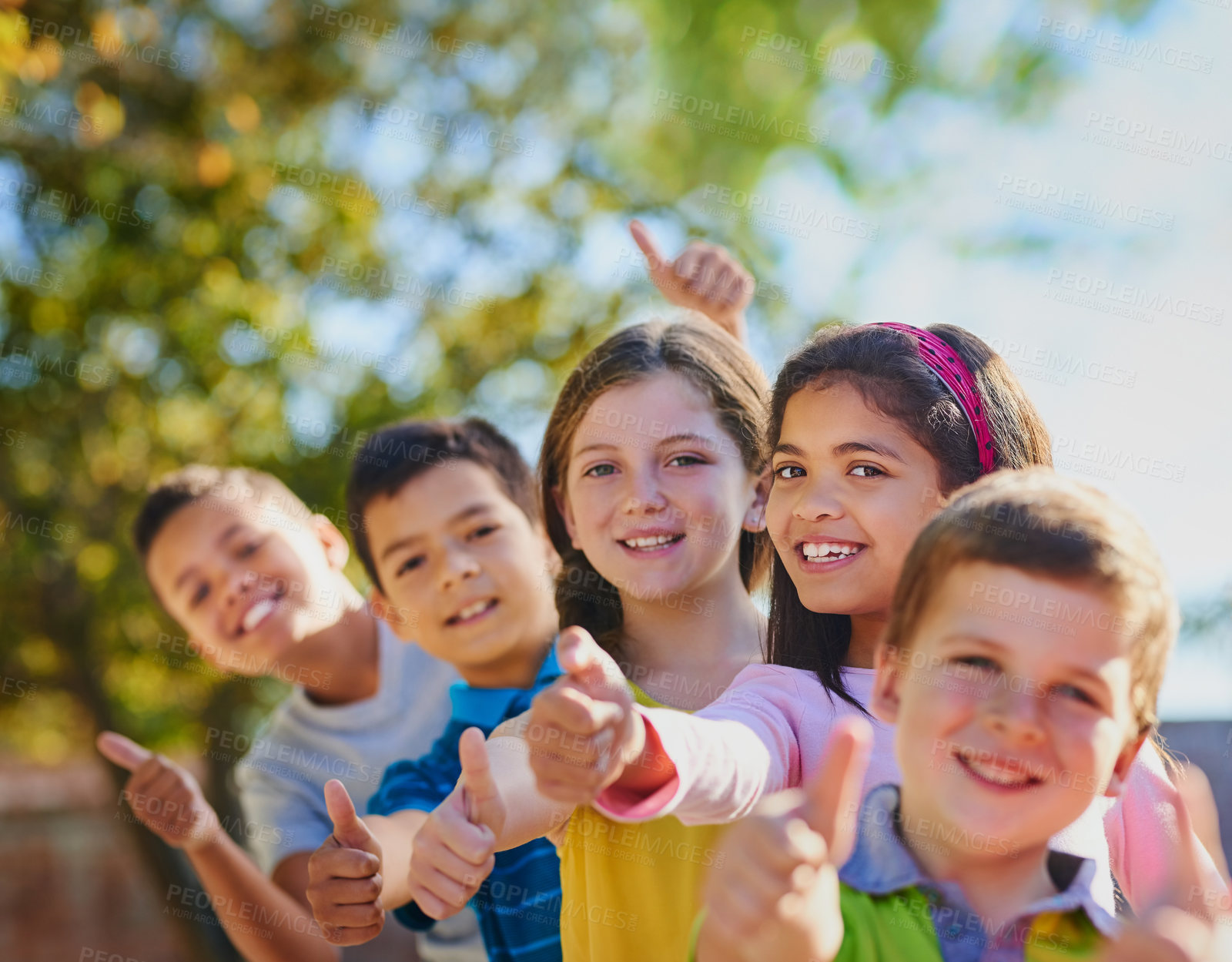 Buy stock photo Shot of a diverse group of children showing thumbs up outside