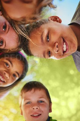 Buy stock photo Shot of a diverse group of young friends huddled together outside