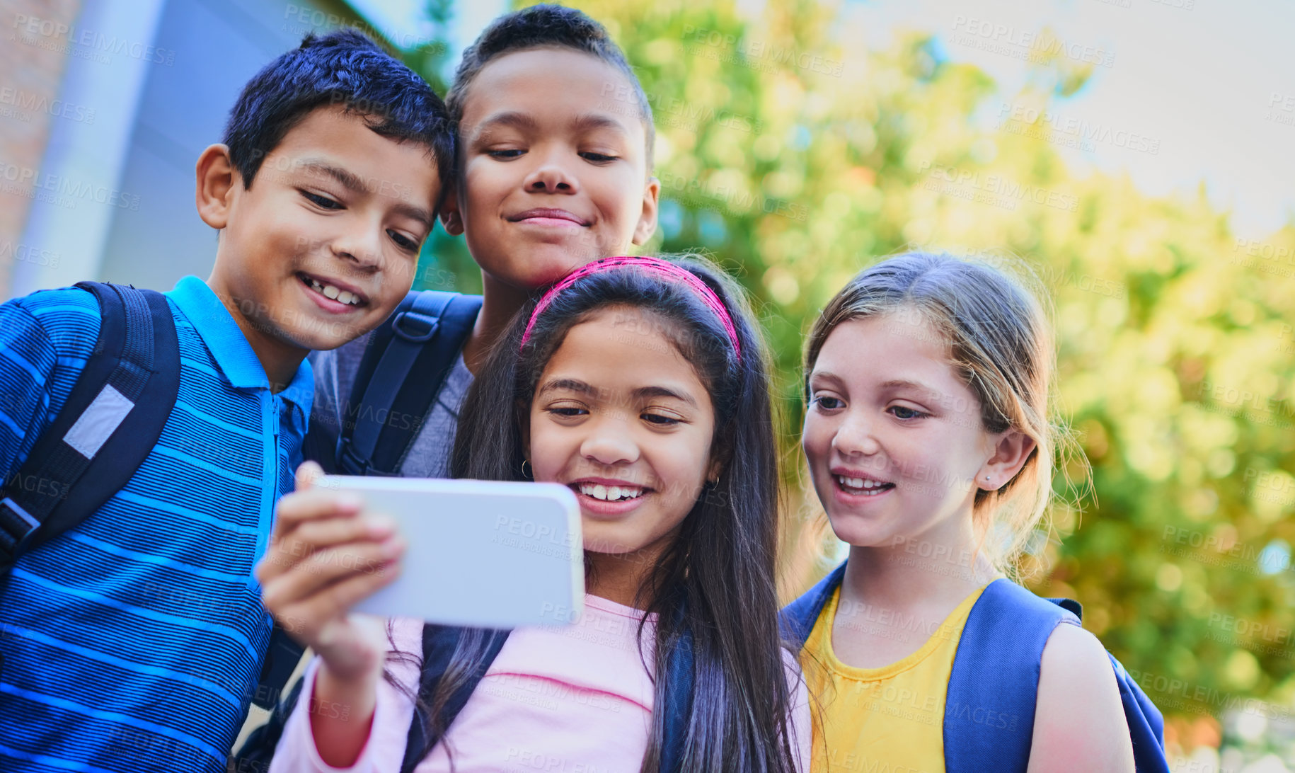 Buy stock photo Shot of a diverse group of children taking a selfie outside