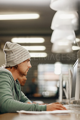 Buy stock photo Cropped shot of a young male university student studying in the library