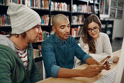 Buy stock photo High angle shot of three young university students studying in the library
