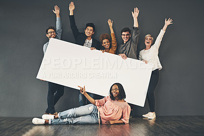 Buy stock photo Studio shot of a diverse group of people holding up a placard against a grey background