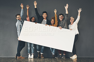 Buy stock photo Studio shot of a diverse group of people holding up a placard against a grey background