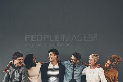 Buy stock photo Studio shot of a diverse group of creative employees embracing each other against a grey background
