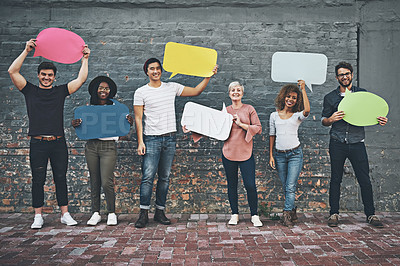 Buy stock photo Shot of a diverse group of people holding up speech bubbles outside