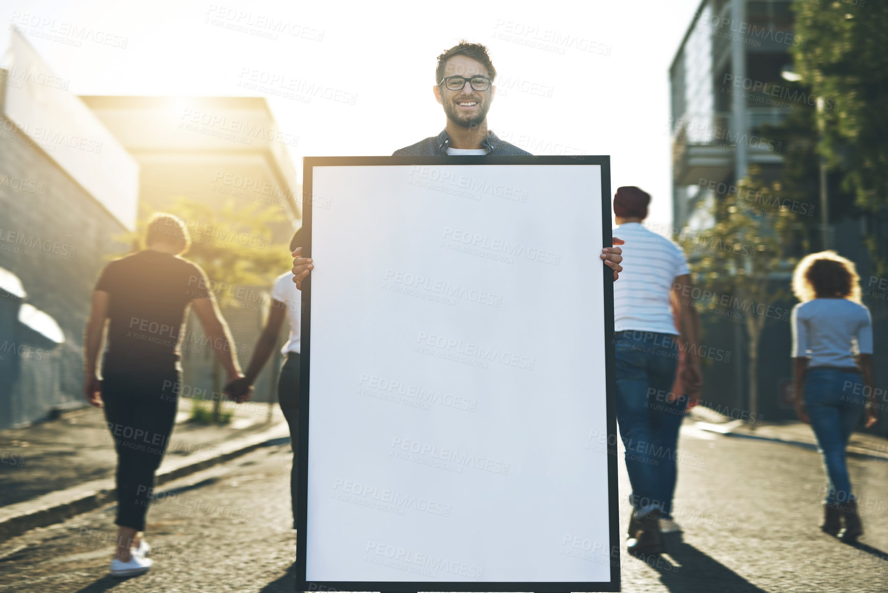 Buy stock photo Shot of a young man holding up a placard outside