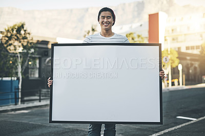 Buy stock photo Shot of a young man holding up a placard outside