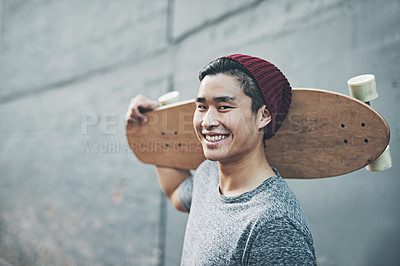 Buy stock photo Shot of a young man holding a skateboard outside