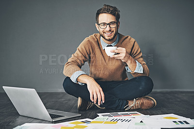 Buy stock photo Studio portrait of a young businessman working on a laptop against a grey background