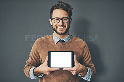 Buy stock photo Studio portrait of a young man holding a digital tablet with a blank screen against a grey background