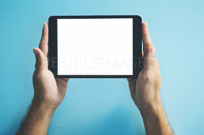 Buy stock photo Studio shot of a man holding a digital tablet with a blank screen against a blue background