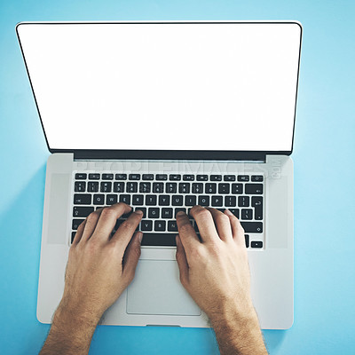 Buy stock photo Studio shot of a man typing on a laptop with a blank screen against a blue background