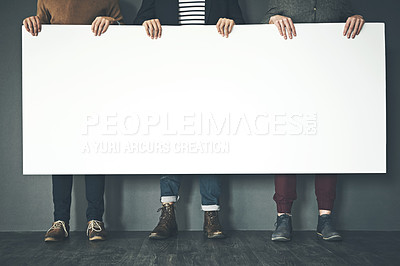 Buy stock photo Studio portrait of a group of men holding a blank sign against a grey background