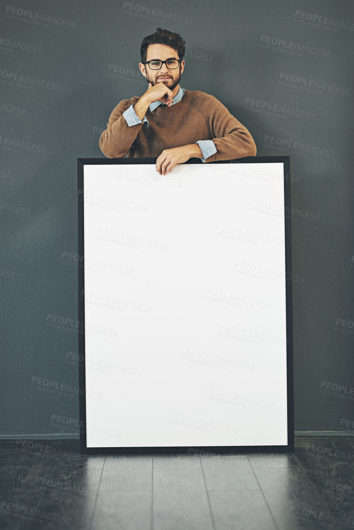 Buy stock photo Studio portrait of a young man holding a blank sign against a grey background