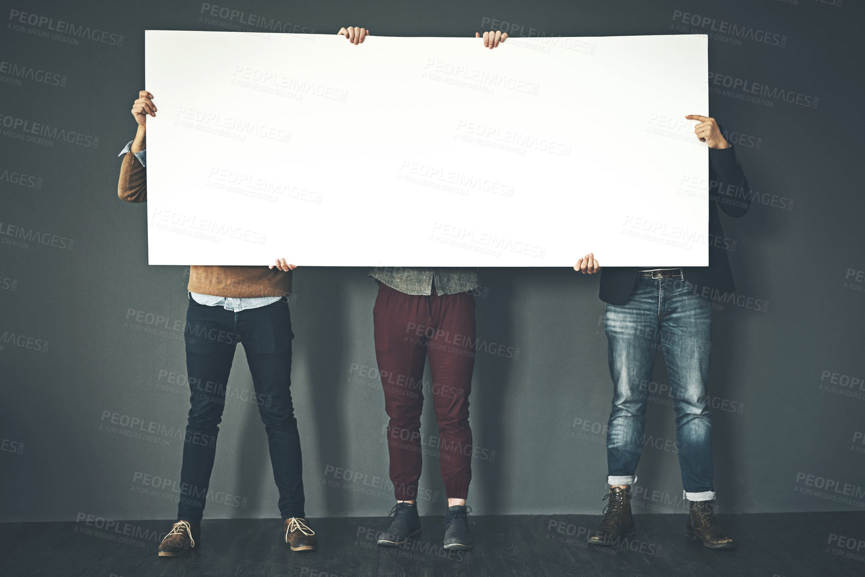 Buy stock photo Group of businesspeople holding up a copyspace sign voicing their opinion at work with a grey background. People with blank poster advertising, marketing and express or convey important messages 