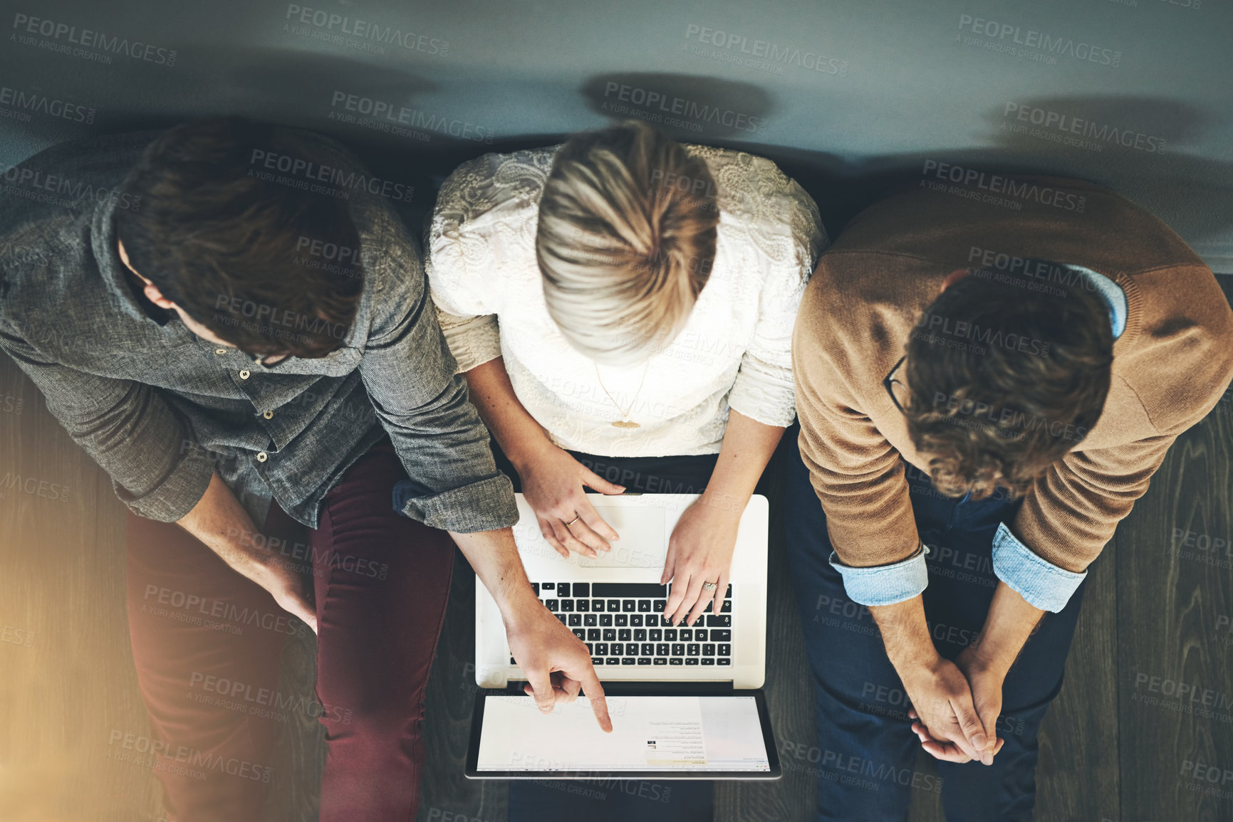 Buy stock photo A group of planning, researching and professional business people working together on a laptop while sitting on the floor top view. A team of designers searching the web or completing a project