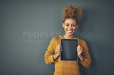 Buy stock photo Studio portrait of a young woman holding a digital tablet with a blank screen against a grey background