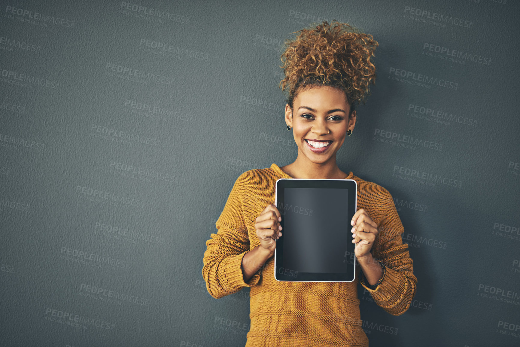 Buy stock photo Studio portrait of a young woman holding a digital tablet with a blank screen against a grey background