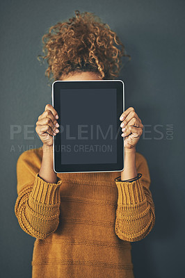 Buy stock photo Studio shot of a young woman holding a digital tablet with a blank screen against a grey background