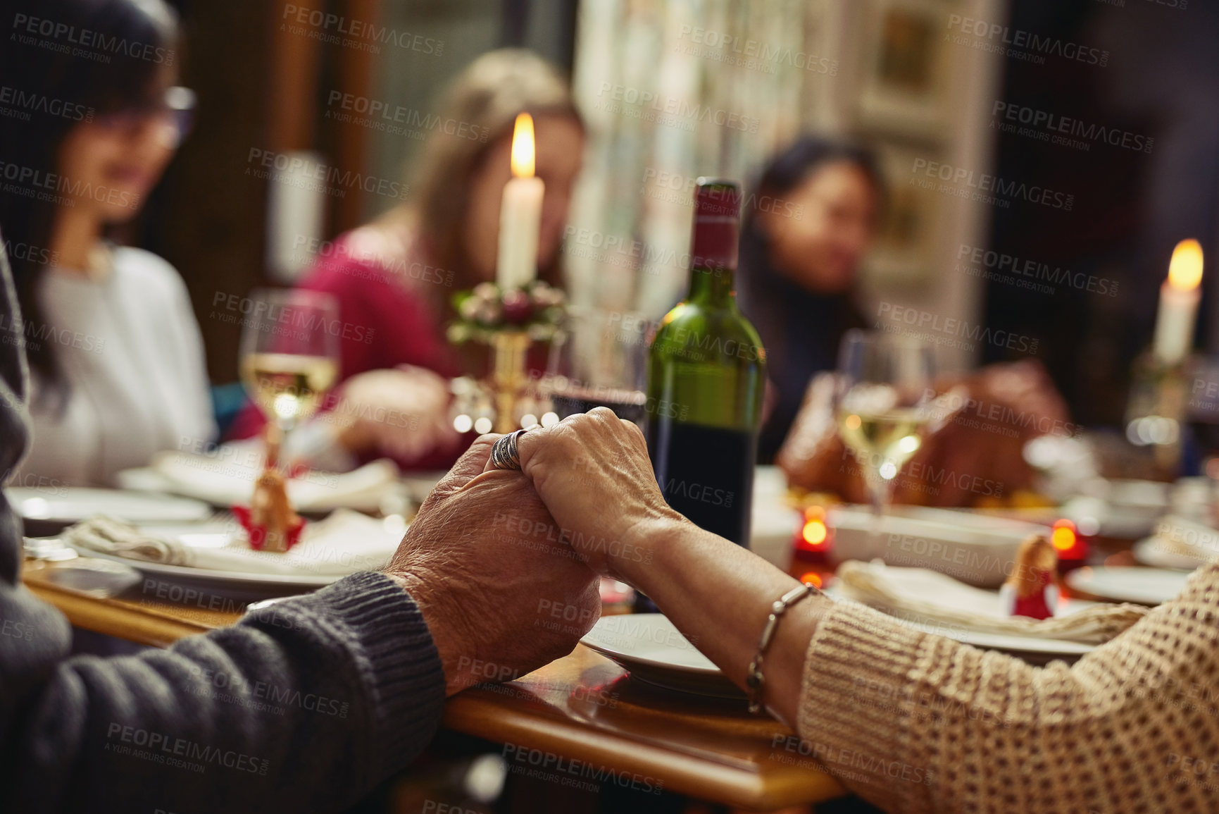 Buy stock photo Family, people holding hands in prayer and at dinner table with champagne. Praying for food, support or love and adults gather for celebration or thanksgiving in dining room at their home.