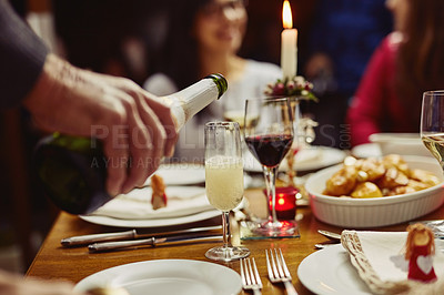 Buy stock photo Closeup shot of a person pouring wine into a glass at a dining table