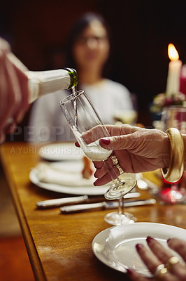 Buy stock photo Closeup shot of a person pouring wine into a glass at a dining table