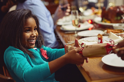 Buy stock photo Shot of an adorable little girl opening a Christmas cracker with her family