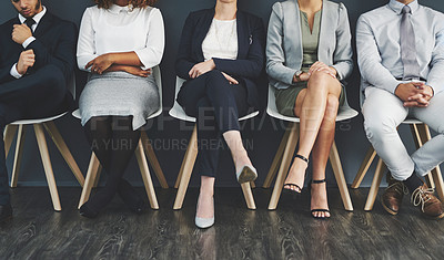 Buy stock photo Studio shot of a group of businesspeople waiting in line on chairs against a gray background