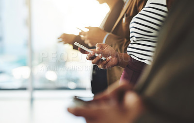 Buy stock photo Cropped shot of businesspeople using their cellphones while standing in a row
