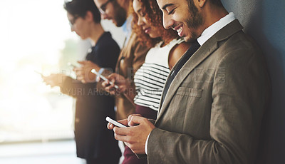 Buy stock photo Cropped shot of businesspeople using their cellphones while standing in a row