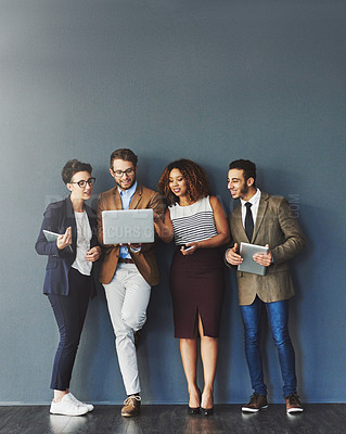 Buy stock photo Studio shot of a group of businesspeople using wireless technology together while standing in line against a gray background