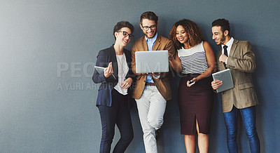 Buy stock photo Diverse group of business people with technology browsing, searching and reading positive online reports, data or charts on laptop. Team of creative marketing agents against grey wall with copy space