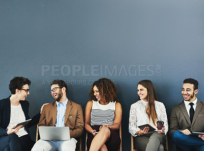 Buy stock photo Studio shot of a group of businesspeople using wireless technology and talking while waiting in line against a gray background
