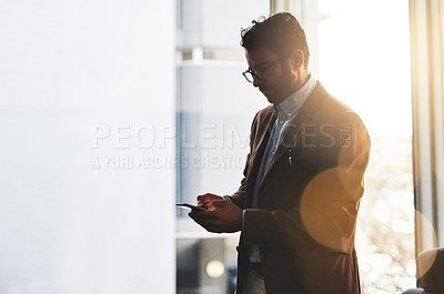 Buy stock photo Cropped shot of a handsome businessman using a mobile phone in his office