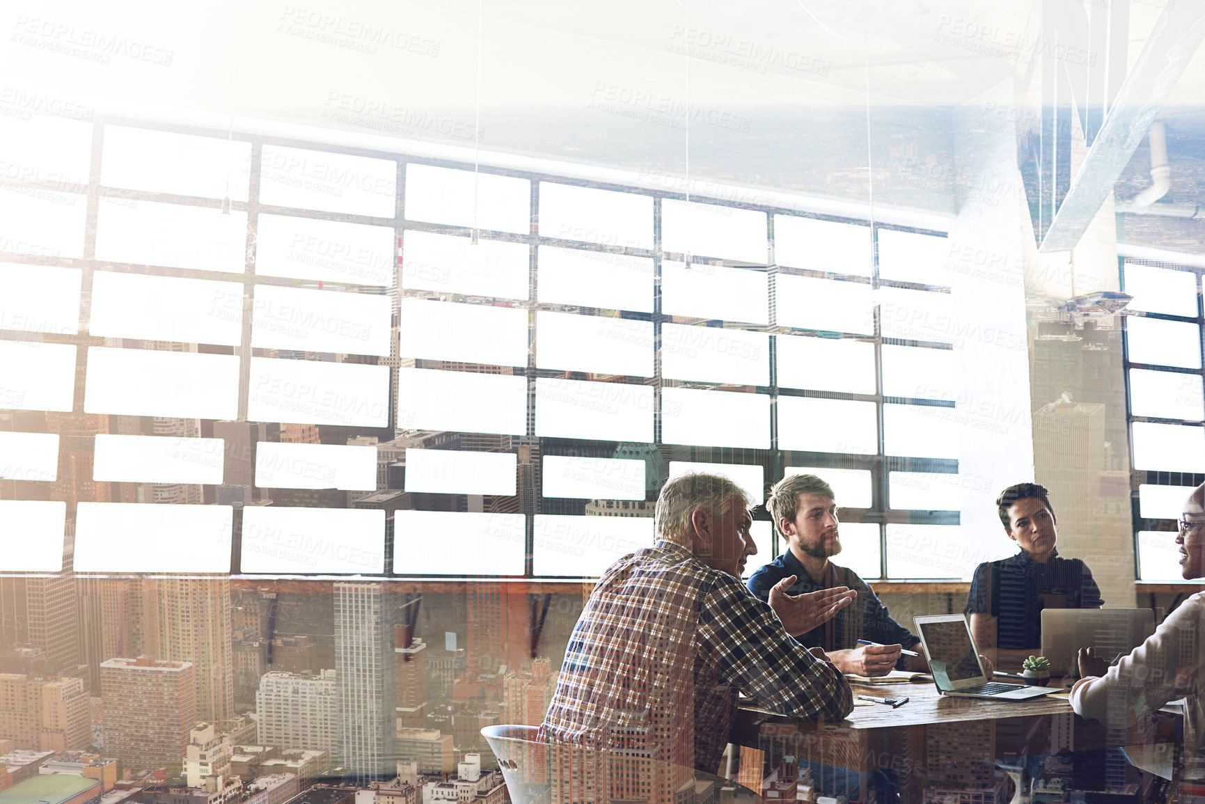 Buy stock photo Multiple exposure shot of businesspeople having a meeting superimposed over a cityscape