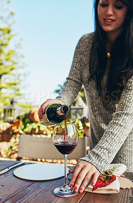 Buy stock photo Shot of a woman pouring herself some wine