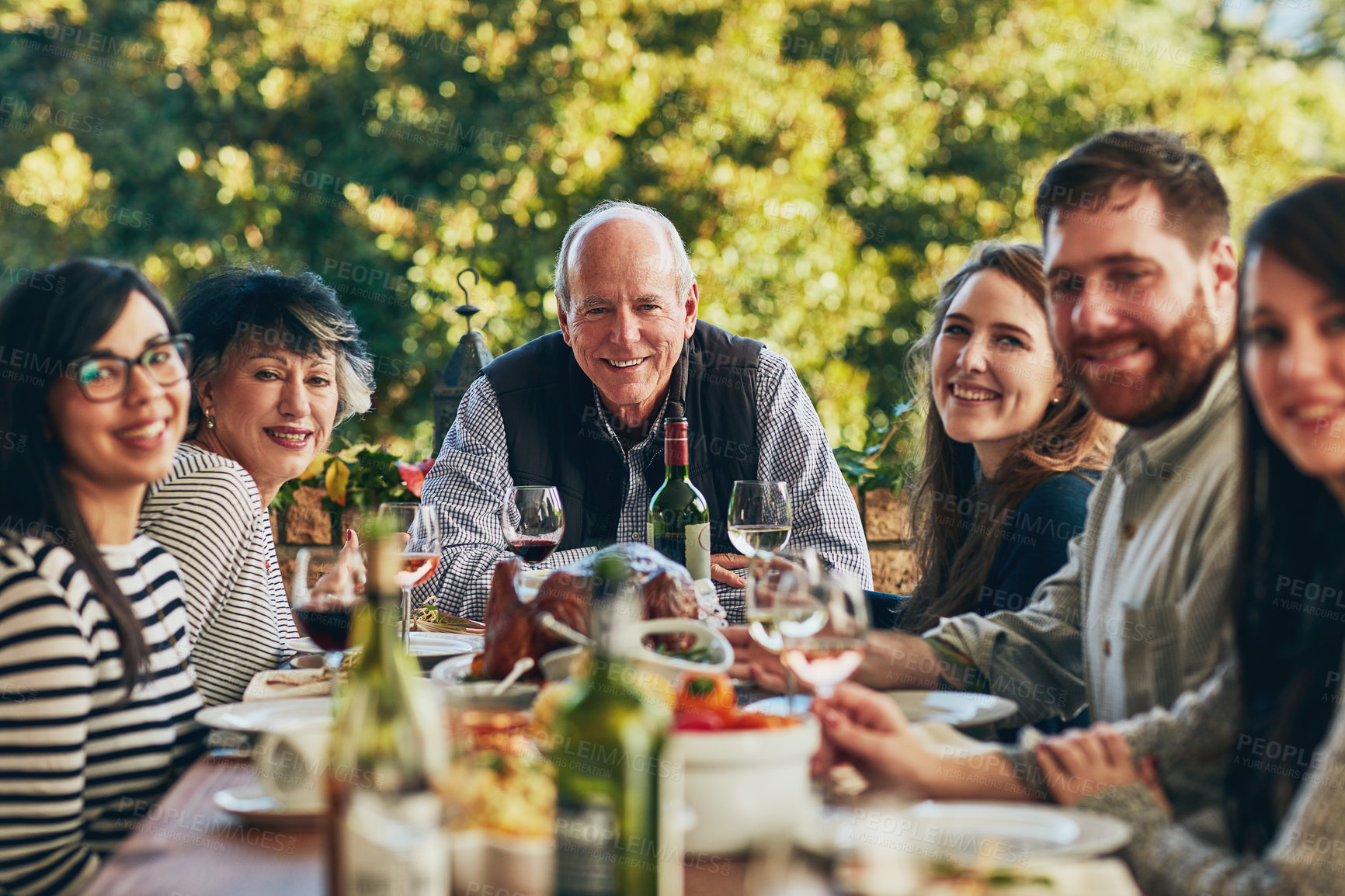 Buy stock photo Cropped shot of a group of people sitting together during a feast at a dining table