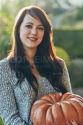 Buy stock photo Portrait of a young woman holding a pumpkin outside