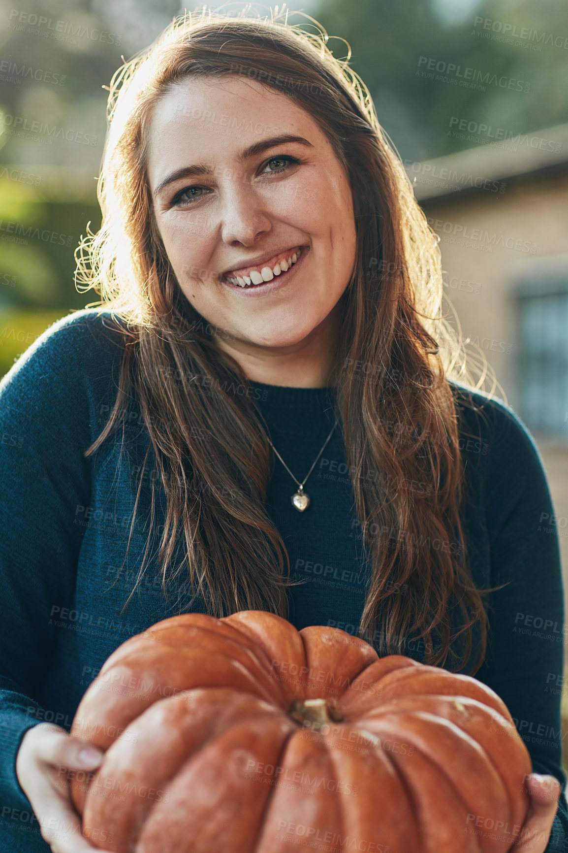 Buy stock photo Portrait of a young woman holding a pumpkin outside