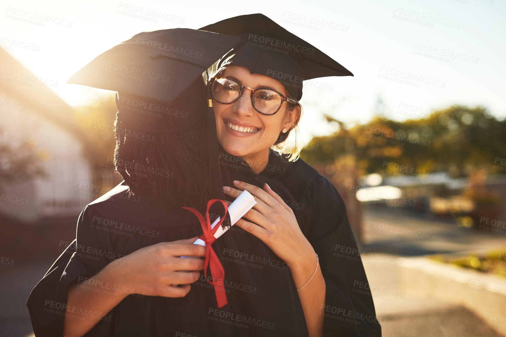 Buy stock photo Hug, students and graduation victory in outdoor, diploma celebration and solidarity for support. People, friends and certified together for university success, embrace and degree achievement goals