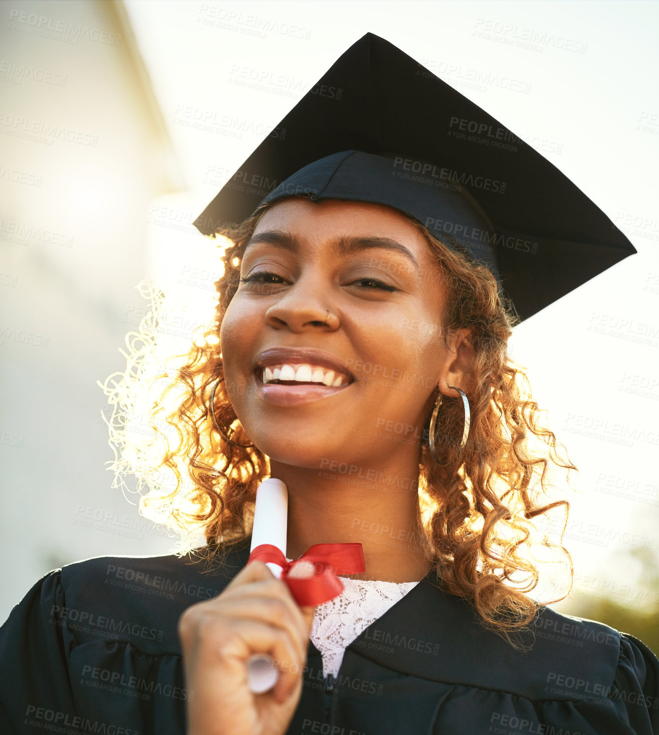 Buy stock photo Portrait of a happy young woman holding a diploma on graduation day