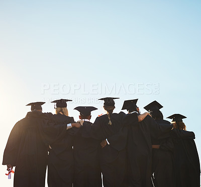 Buy stock photo Rearview shot of a group of university students standing outside on graduation day