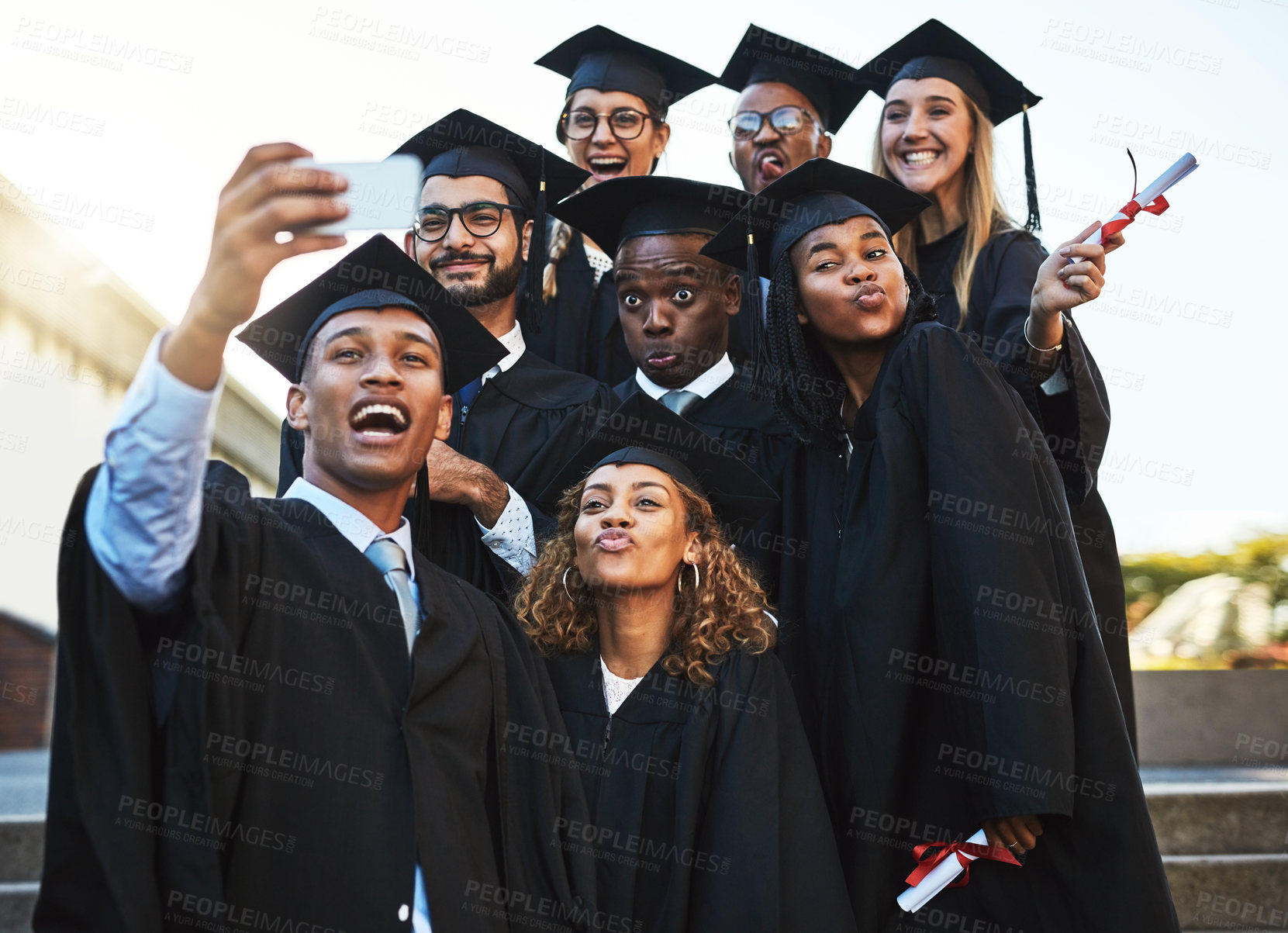 Buy stock photo Shot of a group of students taking a selfie on graduation day
