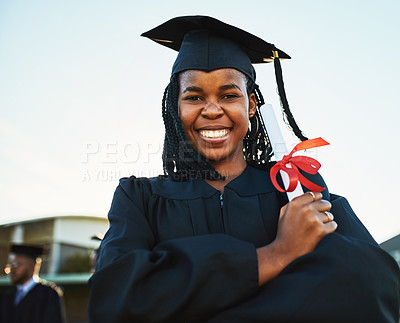 Buy stock photo Portrait of a happy young woman holding a diploma on graduation day