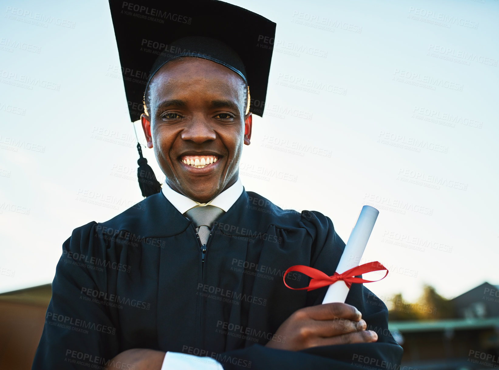 Buy stock photo Portrait of a confident young man holding a diploma on graduation day