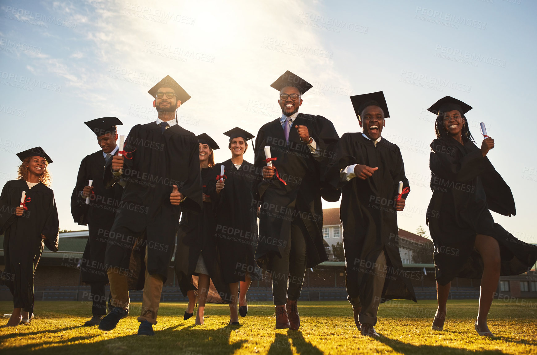 Buy stock photo Graduation, group portrait and run on campus lawn with college success, student celebration and diploma event at university. Friends, outdoor and academy achievement with happy people and freedom