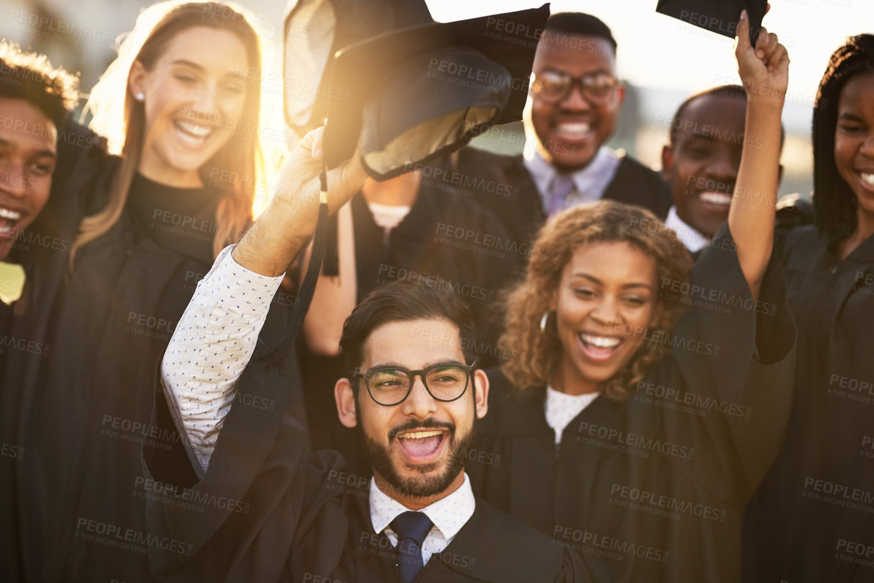 Buy stock photo Happy, people and celebration with graduation cap at university for learning, achievement and success. Excited, students and friends with smile at campus for education, knowledge and qualification