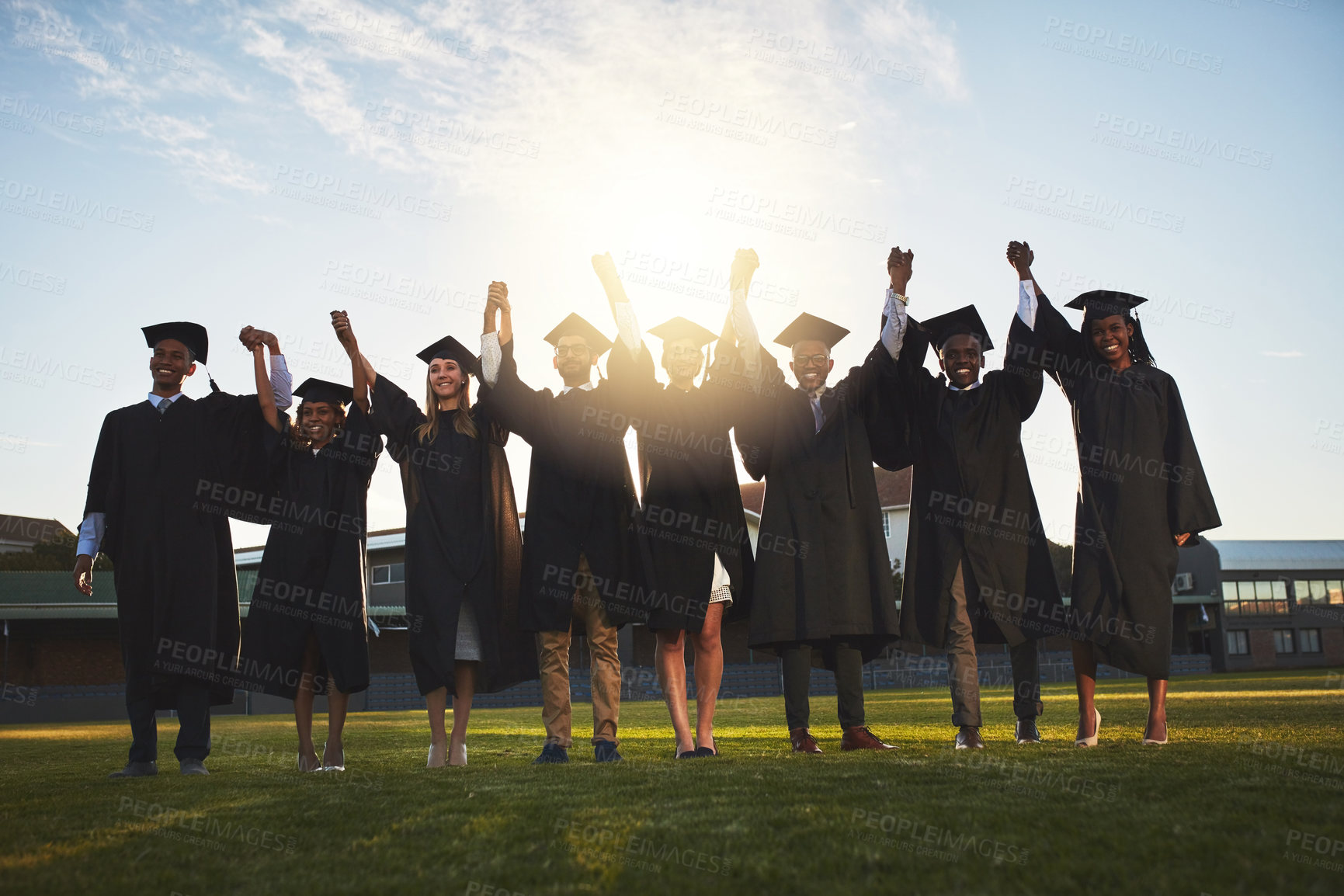 Buy stock photo University, graduation and portrait of people with celebration for education, success or achievement. Happy, students and friends holding hands at field for qualification, knowledge or learning goals